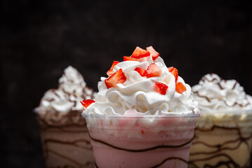 Milkshakes of different flavors on a dark background.