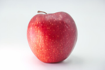 Fresh red apple on a white background showcasing its glossy surface and natural beauty in bright lighting