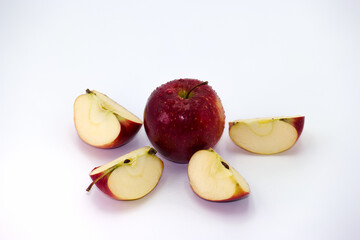 Red apple with slices arranged in a circle on a white background showcasing freshness and vibrant...