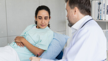 Obraz premium Specialist doctors providing medical treatment and discussing test results with patients in a hospital setting. Healthcare and wellness concept.