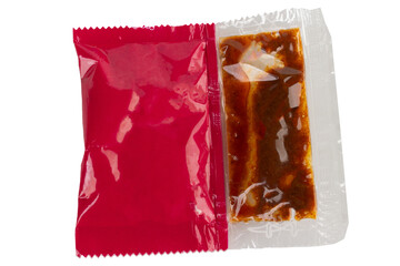 Red instant noodle seasoning packet on white background