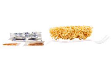 Cup of instant noodles, condiments, plastic forks on white background