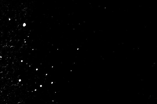 Natural dust particles float in air on black background. Noise black background overlay. Speckled Rough grainy noise dusted structure. Grungy surface. Retro gritty effect overlay.