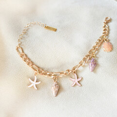 Close up gold charm bracelet jewelry business seashell star fish gold charm bracelet