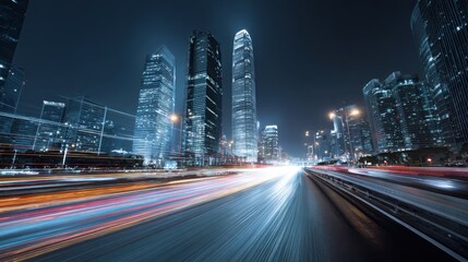 Obraz premium Modern cityscape at night with streaking light trails from traffic