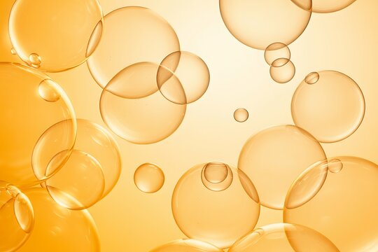 Abstract arrangement of translucent golden orange bubbles and spheres floating in a gradient background with soft lighting and reflections