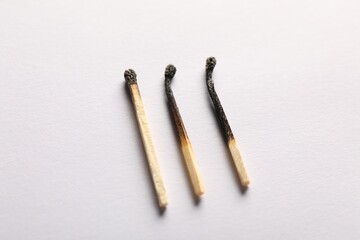Burnt matches on light grey background, closeup