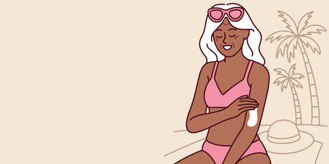 Elderly dark-skinned woman applies SPF to shoulder on sunny beach. She sits near palm trees and protects skin with sunscreen during vacation, banner, copy space