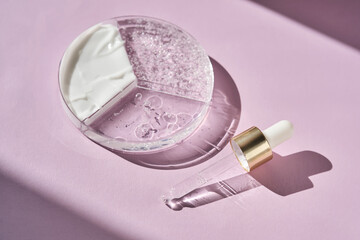 A three-section petri dish with cosmetic care products and a pipette on a purple background.
