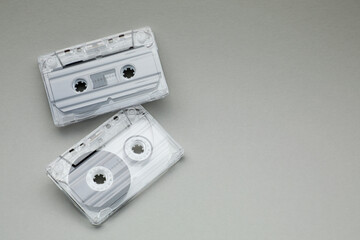 Audio cassettes with magnetic tapes on grey background, flat lay. Space for text