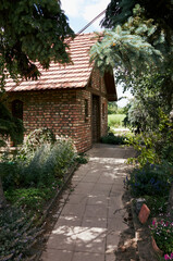 Brick house with a red roof and a path leading to it