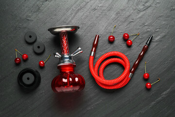 Hookah and cherries on black table, flat lay