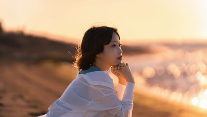 夏の夕暮れにたたずむ女性