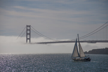 golden gate bridge in fog with sailboat san francisco