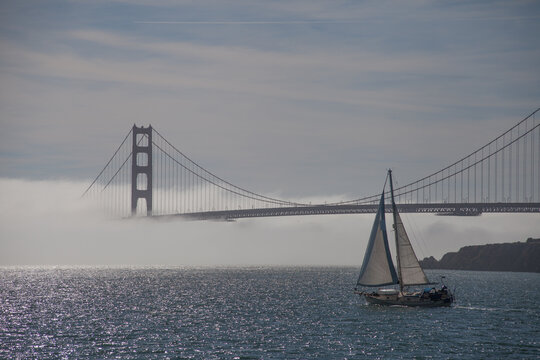 golden gate bridge in fog with sailboat san francisco