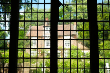 Oxton, Nottinghamshire / England - June 20 2025: Picturesque view through old church window to...
