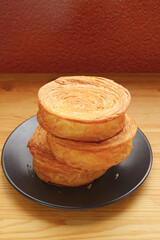 Stack of Delectable Supreme Croissants or New York Rolls on Wooden table