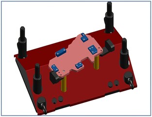 Close up of a red jig with a pink component blue clamps and black pins