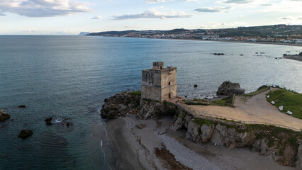 Casares Coastal Watchtower: An ancient watchtower stands on a rocky outcrop at the water's edge,...
