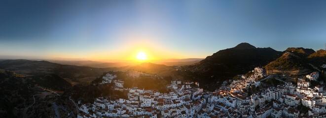 An aerial view captures the dense cluster of whitewashed houses with terracotta roofs, built into...