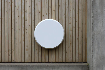 Blank white circular sign mounted on vertical wooden planks with concrete elements blank sign white circle