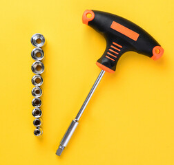 Socket holder with sockets arranged on bright yellow background top view metal tools set