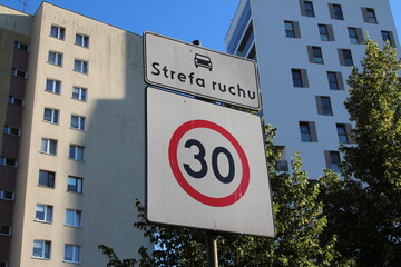 Modern residential apartment building with speed limit sign showing urban development and traffic...