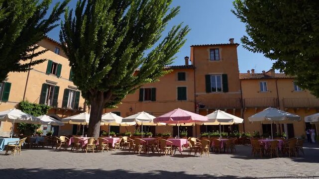 Terrasse de caf&eacute; color&eacute;e sous des arbres dans un village