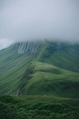 Misty mountain peak, lush green slopes. Nature's grandeur.
