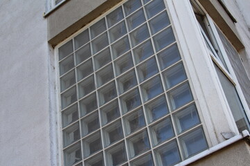 Close-up upward perspective of modern glass office building facade with reflective windows creating geometric pattern