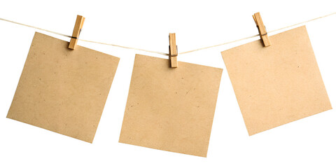 Three blank kraft paper cards hanging on twine with wooden clothespins; rustic, minimalist,...