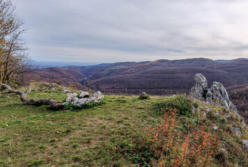 Grassy plateau with fire ring and panoramic view over the forested ridges of the Bükk Mountains at...