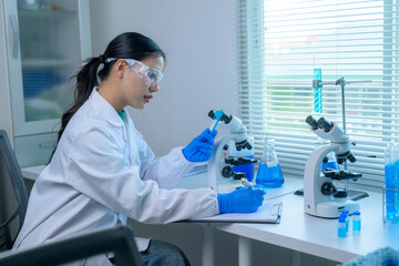 Researcher examining samples under microscopes in a bright lab