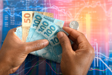 Male hands holding Brazilian real banknotes