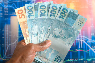 Male hands holding Brazilian real banknotes