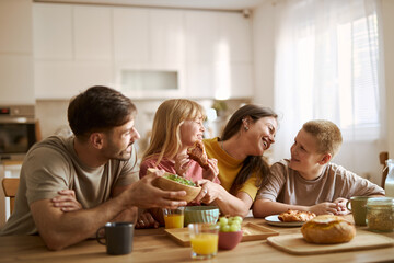 Happy family enjoying while having breakfast  in dining room. 