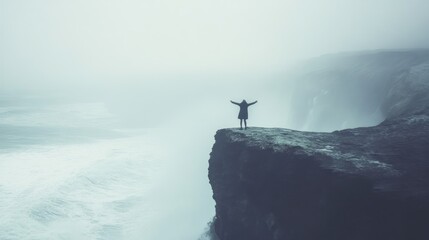 Person on cliff overlooking foggy ocean