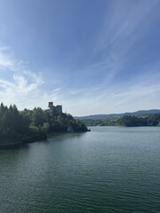 Castle above lake with hills