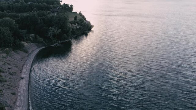 Drone overflight of Lake Ontario from the New York shore looking west towards a sunset in mid summer