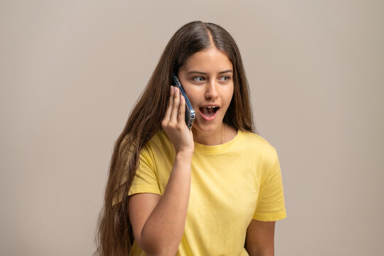 Young woman talking on the phone, having a pleasant conversation.