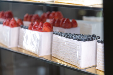 Delicious strawberry and blueberry cakes displayed in a bakery case