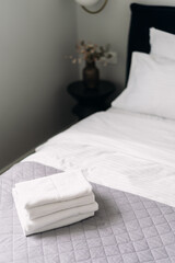 Elegant hotel bedroom with neatly arranged bedding and towels ready for guests
