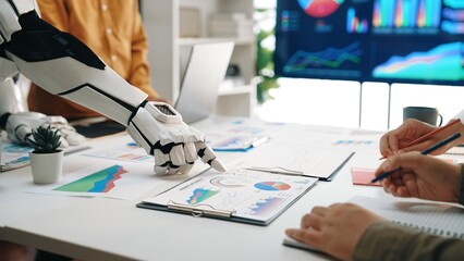 A robot collaborates with a human in a modern office showcasing various charts and graphs on a...