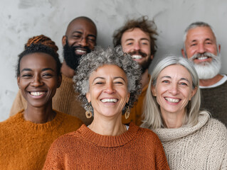 Smiling group of diverse people with different ethnicities, showcasing joy and connection. Their warm sweaters reflect cozy atmosphere, highlighting friendship and unity