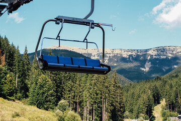 Chairlift Carpathians ascending through mountains on a clear day with lush green forests