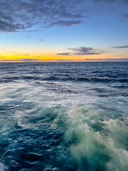Waves from a cruise ship at sea at dusk, Travel concept. No people.