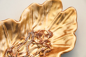 Elegant golden dish holding sparkling jewelry pieces at a decorative display