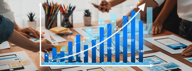 A collaborative team evaluates a detailed business growth chart, engaging in strategic discussions to enhance performance in a modern office setting filled with creativity. Amity