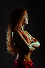 Young fitness woman posing on black background