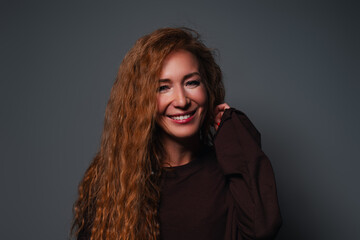 Young laughing woman studio portrait on gray background